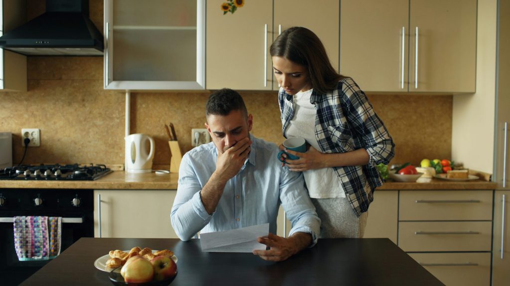 A couple at their kitchen table going over bills and paperwork